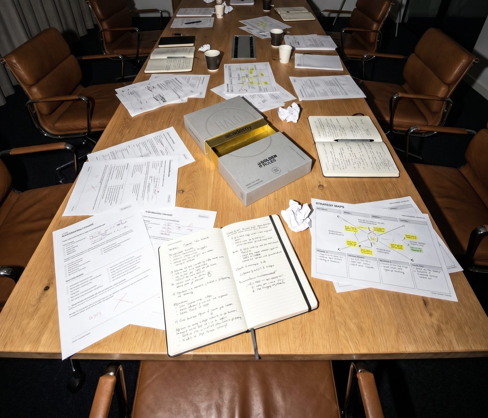 Zwei Personen arbeiten am Tisch mit Notizbüchern und der GoldenRules Box