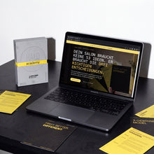 HALO GoldenRules Box neben einem Laptop mit der Box-Seite des HALO Shops auf schwarzem Tisch